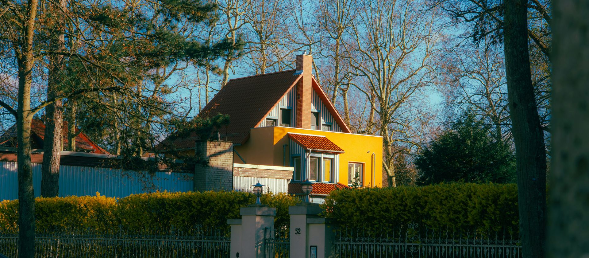 A bright yellow house with a red roof